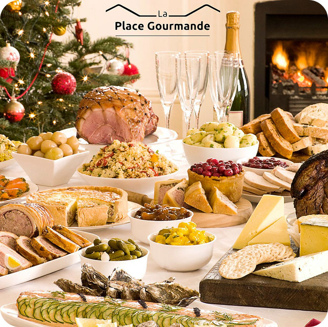 Table de Noël avec plats, sapin illuminé et cheminée en arrière-plan