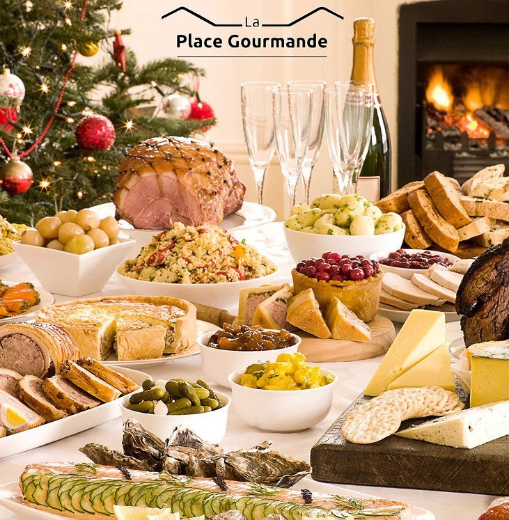 Table de Noël avec plats, sapin illuminé et cheminée en arrière-plan